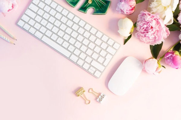 Elegant workspace with digital planner, floral accents, keyboard, and mouse, suitable for productivity, goal setting, and planning. Perfect for entrepreneurs, bloggers, and organization enthusiasts.